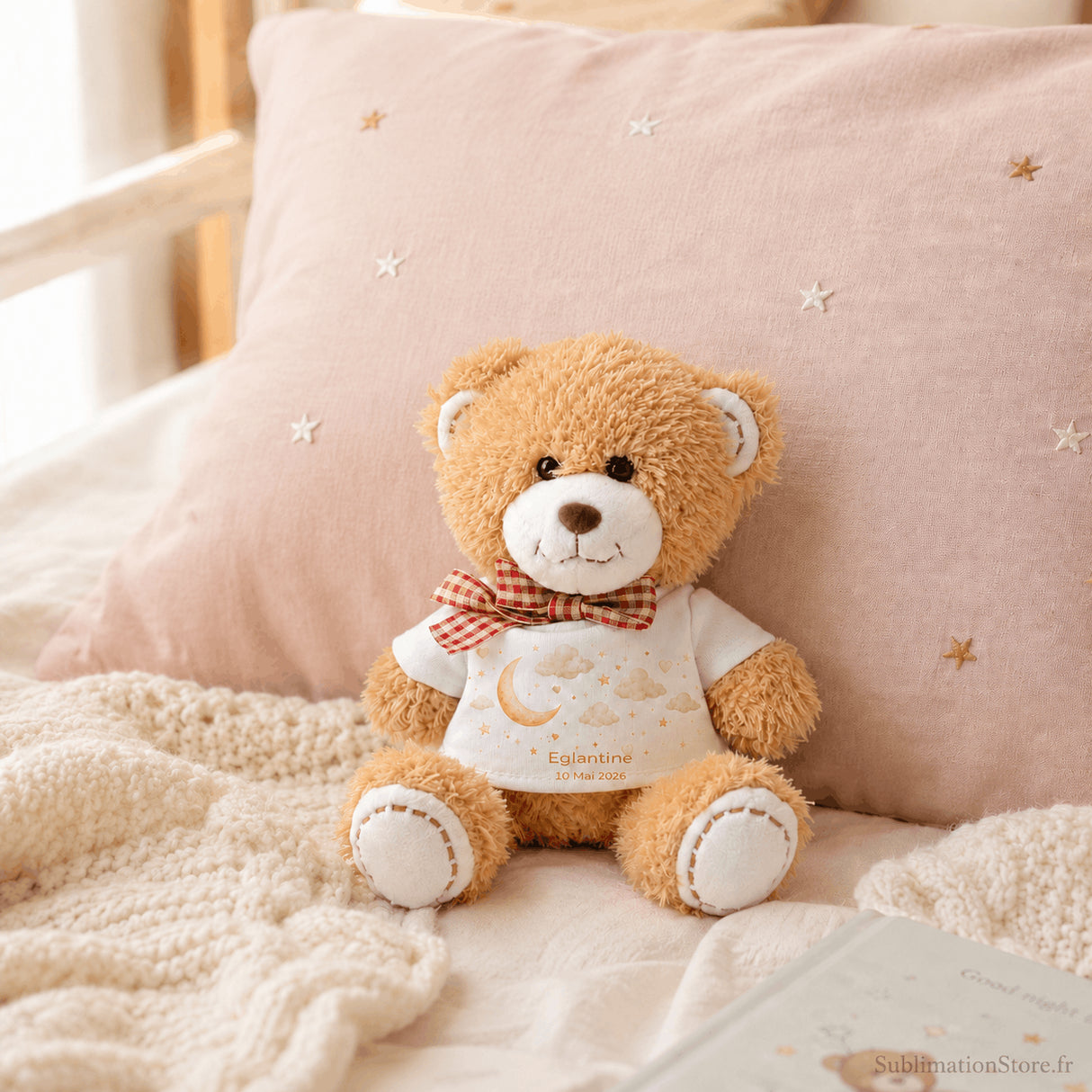 Bradou peluche personnalisée posée sur lit chambre bébé