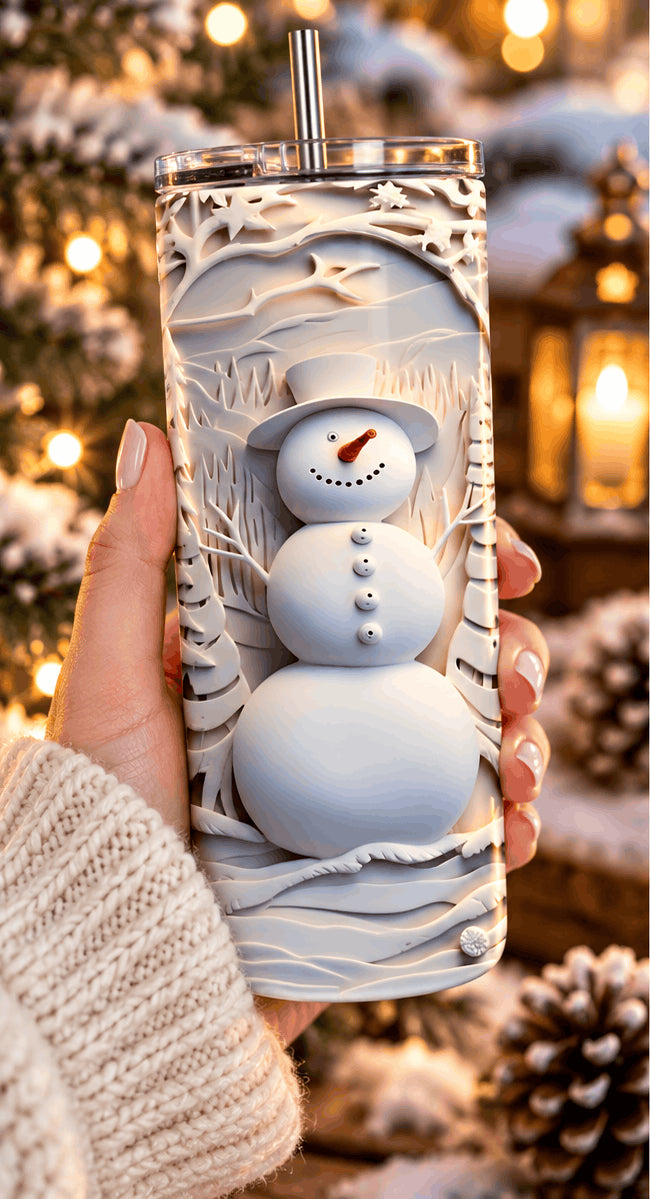 Tumbler bonhomme de neige tenu dans la main, avec pull en maille et lanterne allumée en arrière-plan