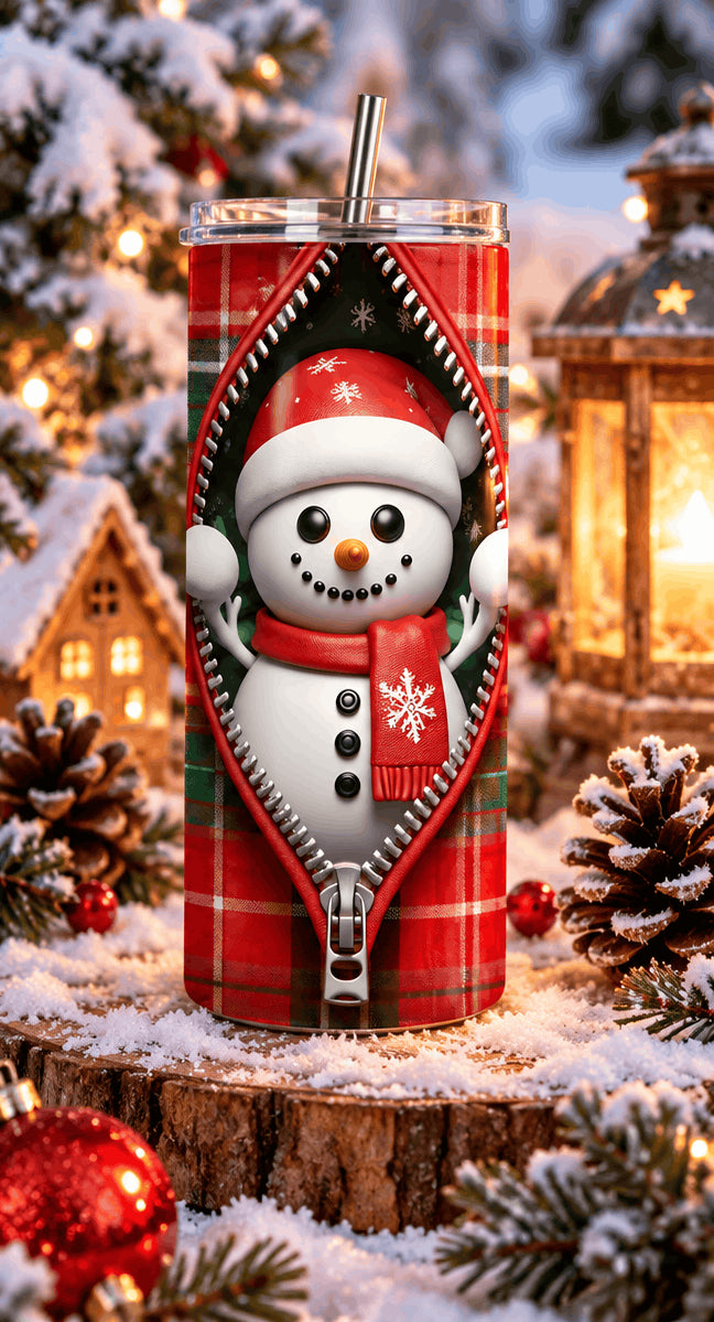 Tumbler bonhomme de neige zippé posé sur une rondelle de bois enneigée, avec lanterne, maisonnette et pommes de pin