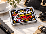Boîte à cigarettes en métal Clopes de Maman posée sur du marbre avec une cigarette, design rouge et noir personnalisable