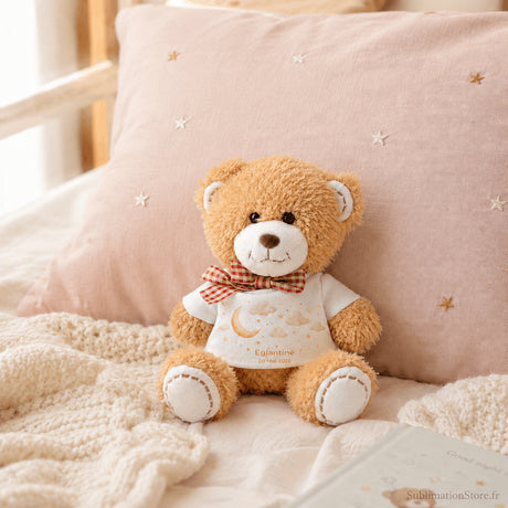 Bradou peluche personnalisée posée sur lit chambre bébé