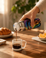 Café versé depuis la gourde isotherme dans la tasse bouchon, table bois