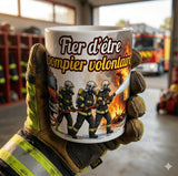 Mug pompier volontaire tenu en main avec illustration intervention incendie et camion de secours