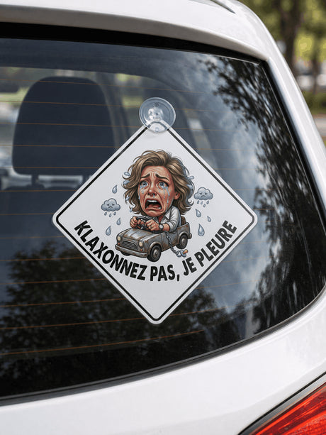 panneau humoristique klaxonnez pas je pleure fixé sur lunette arrière voiture