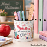 Pot à crayons maîtresse fleuri personnalisé sur bureau de classe devant tableau Merci Maîtresse avec pomme rouge