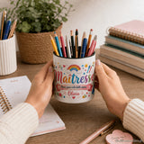 Pot à crayons maîtresse personnalisé tenu en mains au-dessus d'un bureau avec cahier et post-it