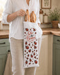 Femme tenant sac à baguettes Que du Bonheur coccinelles dans cuisine